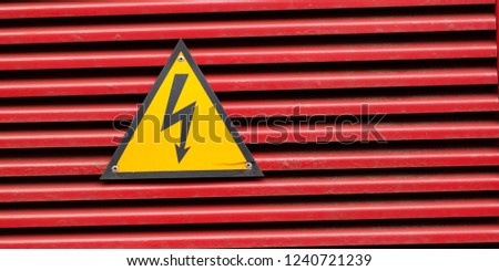 high voltage sign on a bright red surface
