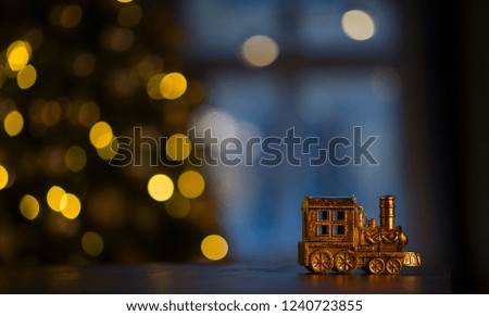 Christmas toy train on the background of Christmas garland
