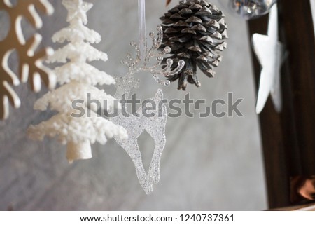 on the background of a gray wall Christmas toys, an element of festive decor, deer and cones, white Christmas tree