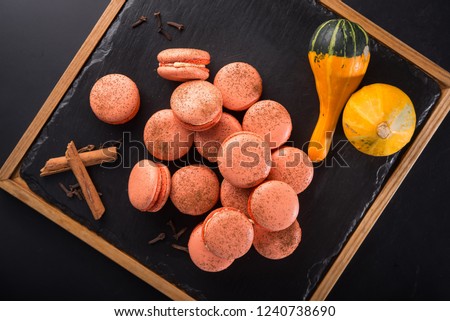 Tasty pumpkin macaroons on a black slate. traditional thanksgiving food