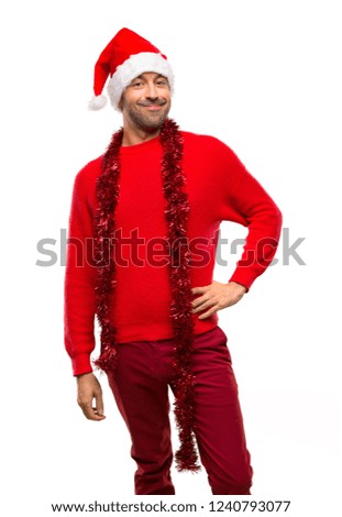 Man with red clothes celebrating the Christmas holidays posing with arms at hip and smiling on isolated white background