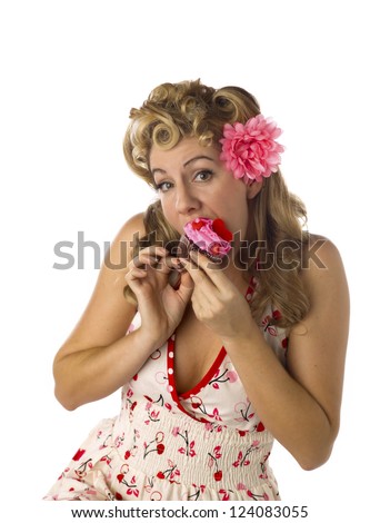 Portrait of a beautiful young woman eating strawberry cupcake against white background