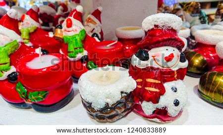 Beautiful Christmas decoration. Christmas ornaments in the form candle-snowman, in the frame in the background, looks other decorations.