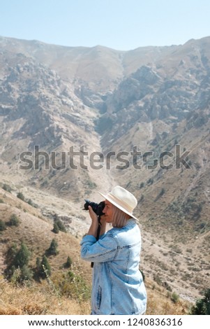 Hiker photographer taking picture of the landscape with mountains.