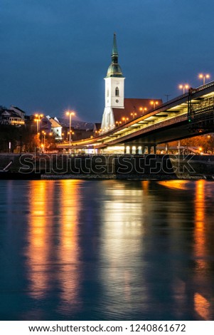 Saint Martin's Cathedral and SNP bridge is mirroring in Danube river, Bratislava, Slovak republic. Night photo. Travel destination.