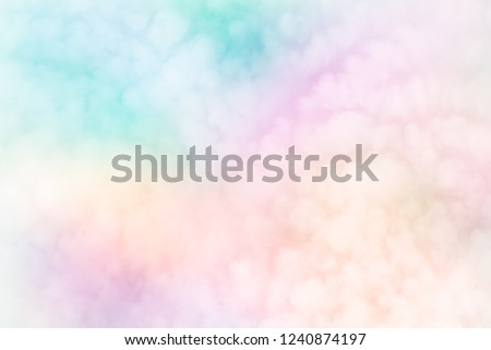 Fluffy white blurred sky clouds on abstract neon pastels of rainbow patchwork  background - Fleecy sky (Cirrocumulus - weather forecast cloud type) brings change.