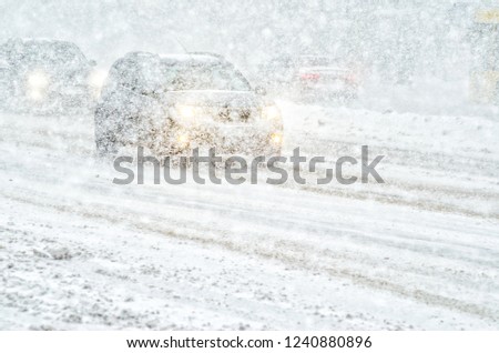Car rides through a snowstorm. Limited vision on the road. Blizzard - car traffic in bad weather conditions Royalty-Free Stock Photo #1240880896