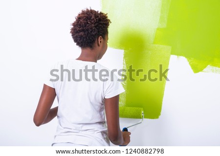 African black girl painting a wall