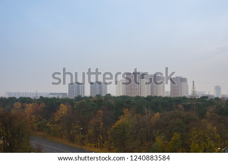 Panoramic view of modern buildings, skyscrapers and autumn trees. Blue sky. Copy space