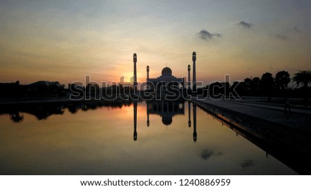 Central mosque at Songkhla southern Thailand  with sunset background and water reflection.             