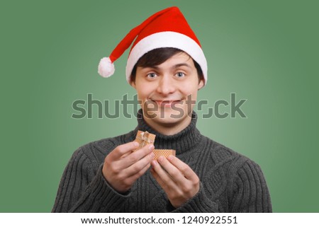 funny guy in santa claus hat holding a gift box