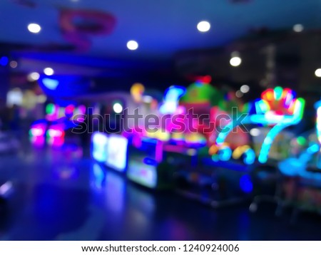 blurred arcade machine game for children game play  in department store. Playground with colorful neon lights and bokeh light. Colorful absract background. Royalty-Free Stock Photo #1240924006