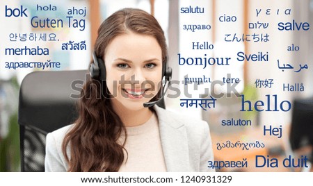 translation, communication and technology concept - smiling female helpline operator with headset at office over greeting words in different foreign languages