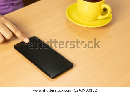 girl hold the phone with coffee and wood table