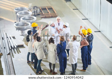 High angle view at group of angry factory workers attacking managers during strike, copy space