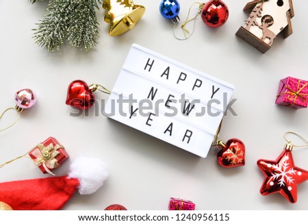 HAPPY NEW YEAR text on lightbox composition and of Christmas decorations on white table background copy space,Business Concept.