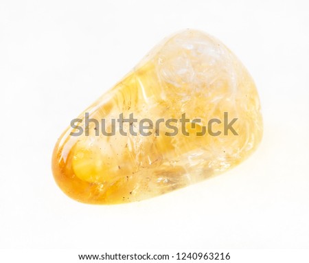 macro photography of natural mineral from geological collection - polished Citrine (yellow quartz) stone on white background Royalty-Free Stock Photo #1240963216