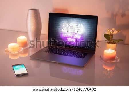 Laptop and smartphone on a glass table.