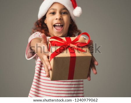Happy african-american girl giving Christmas present