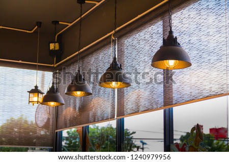 Glass room and curtain, Louvers , shade, blinds, shutters window decoration concept with vintage lamp hanging from the black ceiling. Royalty-Free Stock Photo #1240979956