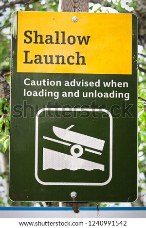 A shallow boat launch sign advising caution