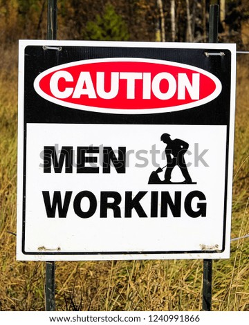 Closeup of a caution men working sign
