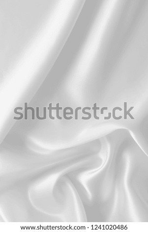Smooth elegant white color silk or satin luxury cloth fabric texture, abstract background design in the wedding theme.