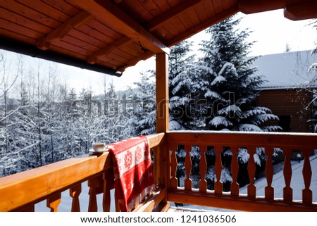 Steaming cup of hot coffee or tea standing on the outdoor table in snowy winter morning. Cozy mug with a warm drink in winter garden. Christmas morning concept.