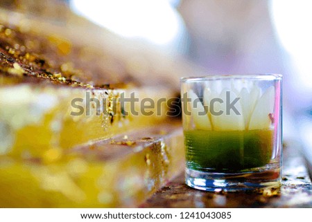 Beautiful Lotus candle in glass decorate at pedestal of Buddha statue.Surrounding by gold leaf.Blurred background and Copy space for text.Concept of soul,believe and Temple decoration.Flat Lay.