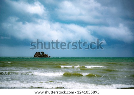 Ocean waves crashing to the shore when the dark clouds came