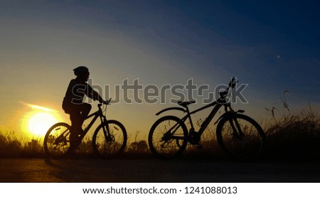 Silhouette picture of young woman exercising by bike In the light of the morning sun is beautiful.
