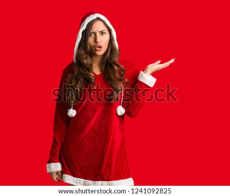 Full body young santa curvy woman holding something on palm hand