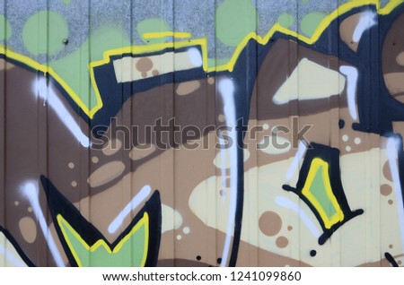 Fragment of graffiti drawings. The old wall decorated with paint stains in the style of street art culture. Colored background texture