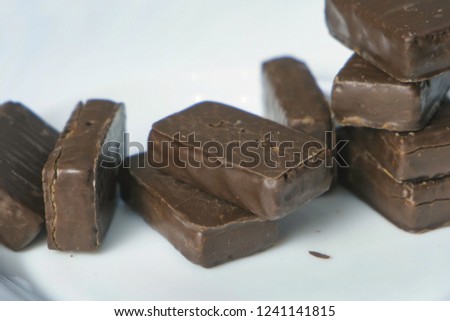 Chocolate candies on a white plate. Concept of unhealthy eating.