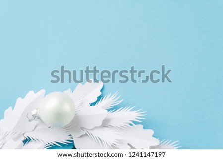 Christmas wreath made of white paper on blue background