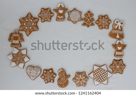 Beautiful traditional decoration for Christmas holidays on white background with lace pattern decorated gingerbread cookies in shape of star,angel,snowman,snowflake,heart,bell,tree in circle