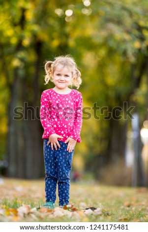 Happy child in beautiful autumn park on sunny fall day