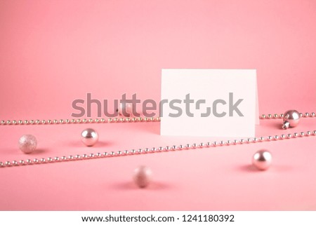 Mock up with vertical invitation card on trendy pastel light pink background with pink christmas balls and pink bead.