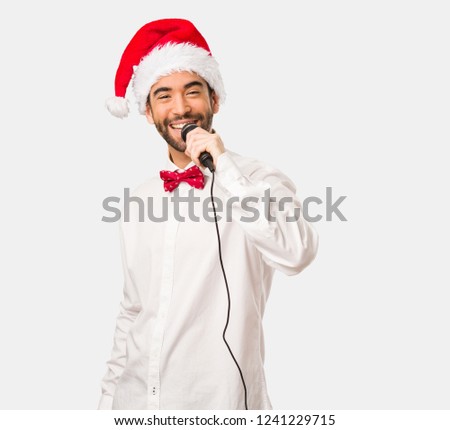 Young handsome man wearing santa hat and celebrating christmas