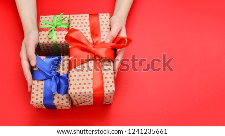 Present in woman hand on red background. 
