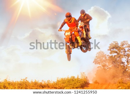Active sports background - jumping motorcycle rider silhouette, blue sky, bright sun