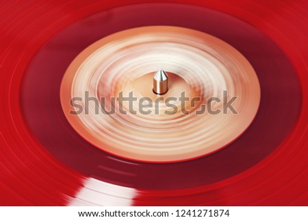Vinyl record rotate. A ray of light on a piece of vinyl. Turntable player. Sound technology for DJ to mix and play music. Red vinyl. The texture of the bands on the vinyl record. Ready background for 