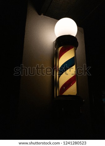 Barbershop pole light at night.
