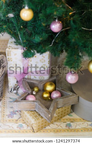 Pink and gold toys and gifts under the Christmas tree
