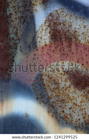 Close up front view of a weathered textured rusty surface. Rough metallic sheet with brown and orange tones. Macro picture of an ancient painted object. Abstract design with colored shapes.