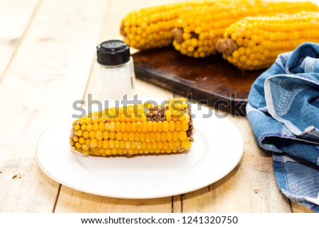 Fresh cooked corn on cutting board  on rustic wooden table