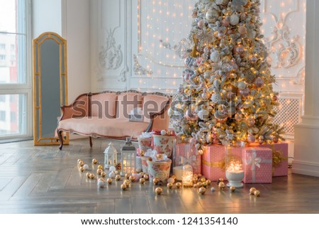 Large bright Christmas decor of the living room in vogue style. Happy new 2019. Beautiful, glowing Christmas tree.