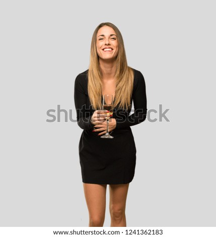 Woman with champagne celebrating new year 2019 smiling a lot while putting hands on chest on isolated grey background