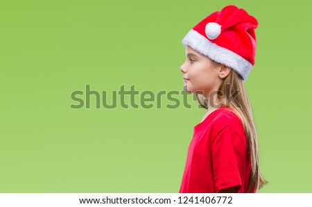 Young beautiful girl wearing christmas hat over isolated background looking to side, relax profile pose with natural face with confident smile.