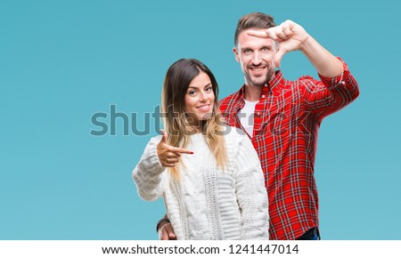Young couple in love wearing winter sweater over isolated background smiling making frame with hands and fingers with happy face. Creativity and photography concept.